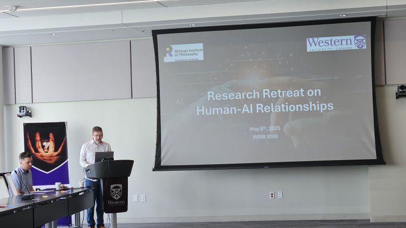 Director Dan Lizotte at podium in front of slide that reads, "Research Retreat on Human-AI Relationships"